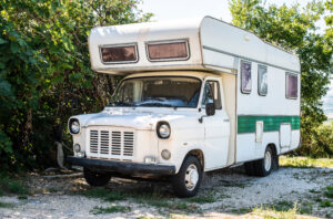 Old white camper bus. Vintage van. Tourism nostalgy concept with old vehicle.